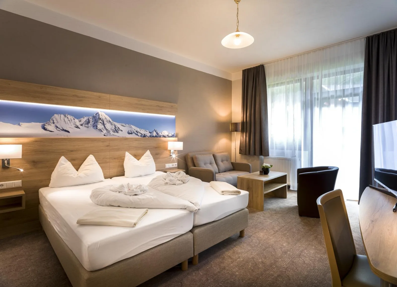 Lichte hotelkamer met twee bedden en een zithoek bij het raam