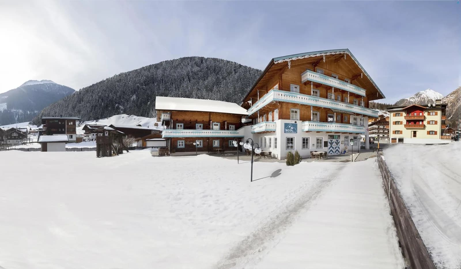 Sporthotel Scol Kals in de winter, met sneeuw rondom en bergen erachter