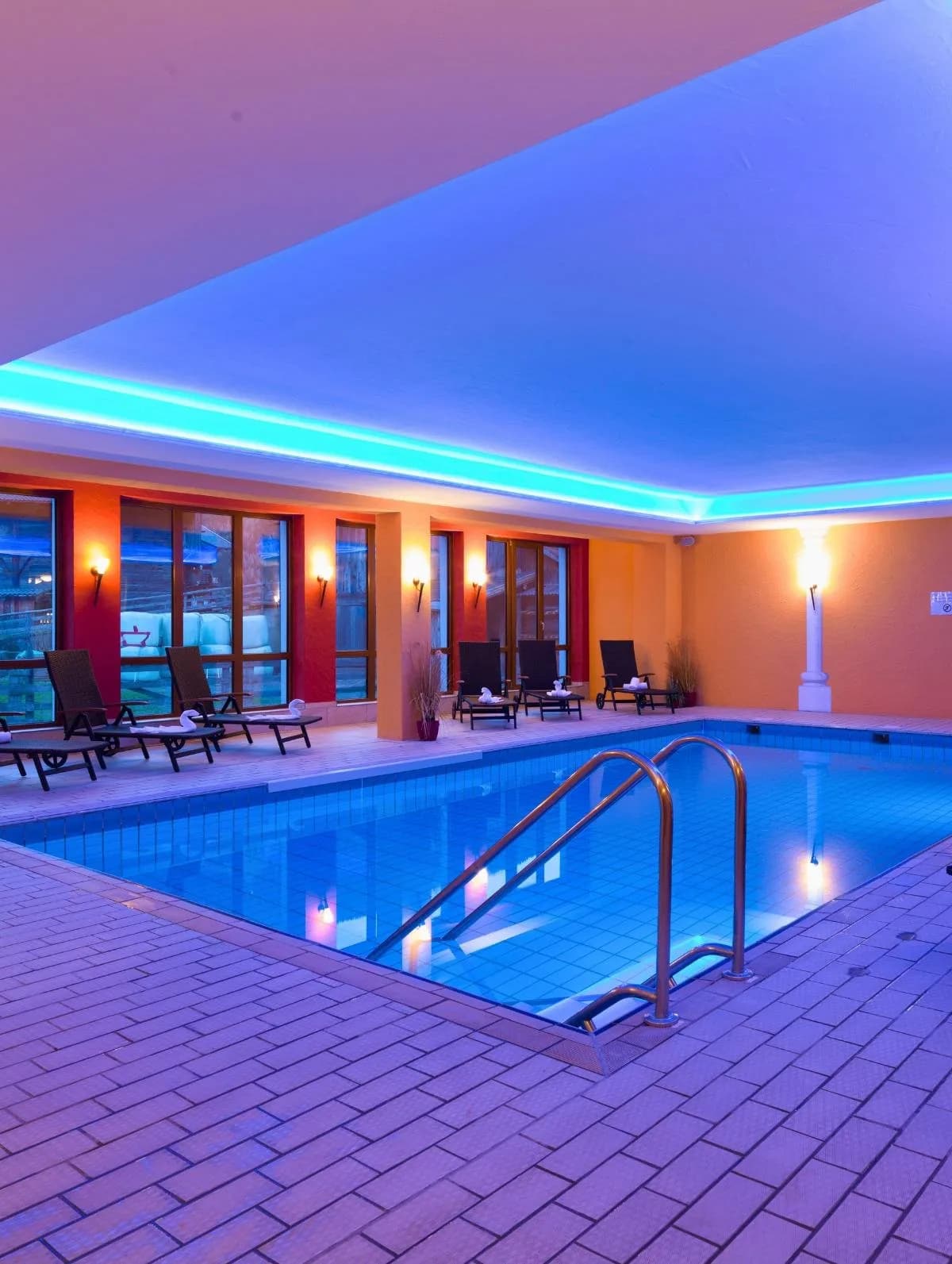 Het verwarmde binnenzwembad van het hotel, met ligstoelen langs de rand