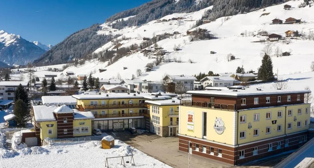 Hotel Wolkensteinbär in Bramberg in de sneeuw, met de bergen erachter